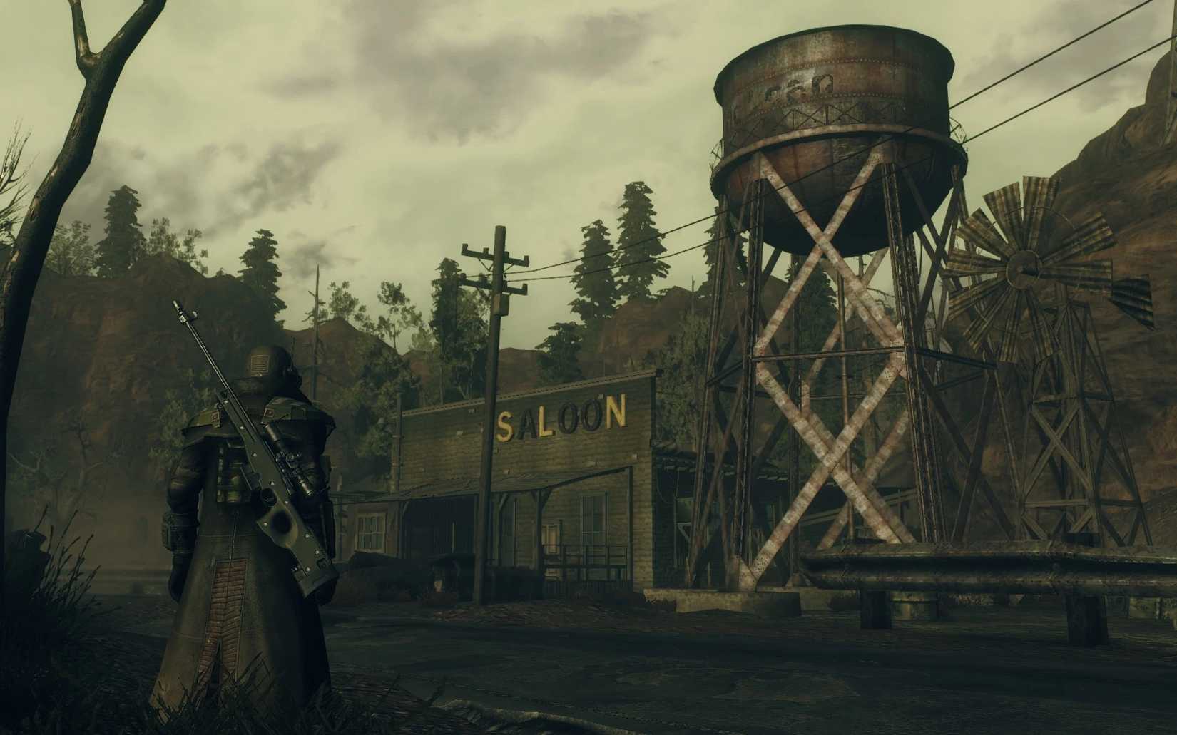 A player exploring a desolate street with a saloon and a water tower in the Forgotten Valley mod for Fallout New Vegas.