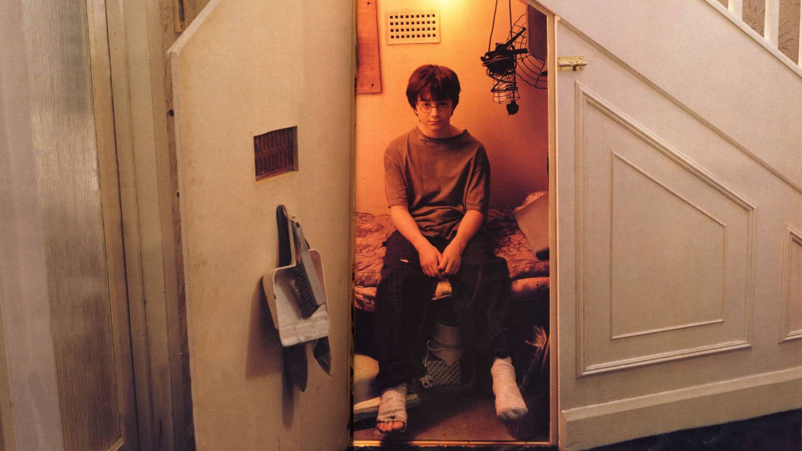 Daniel Radcliffe’s Harry Potter sitting in his cupboard under the stairs in Harry Potter and the Sorcerer’s Stone