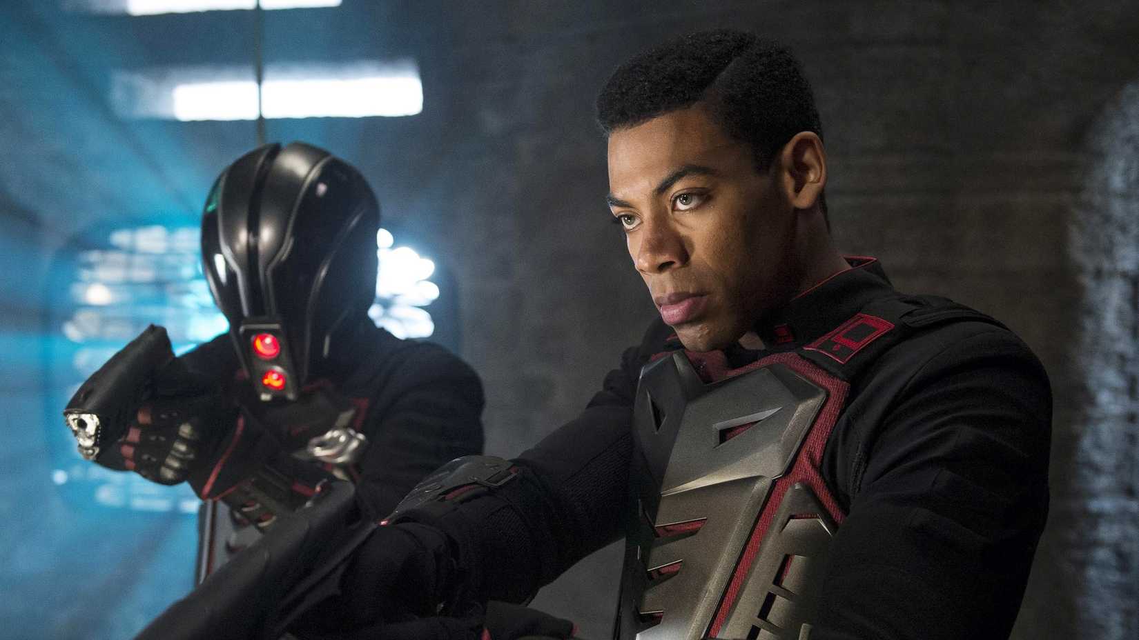 Dev-Em (Aaron Pierre) holding a gun next to a soldier in Krypton