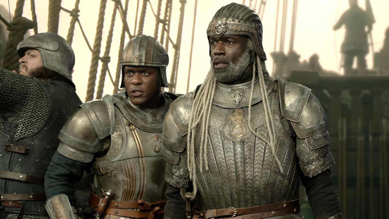 Abubakar Salim's Alyn and Steve Toussaint's Corlys looking intense dressed in armor on a ship in House of the Dragon season 3