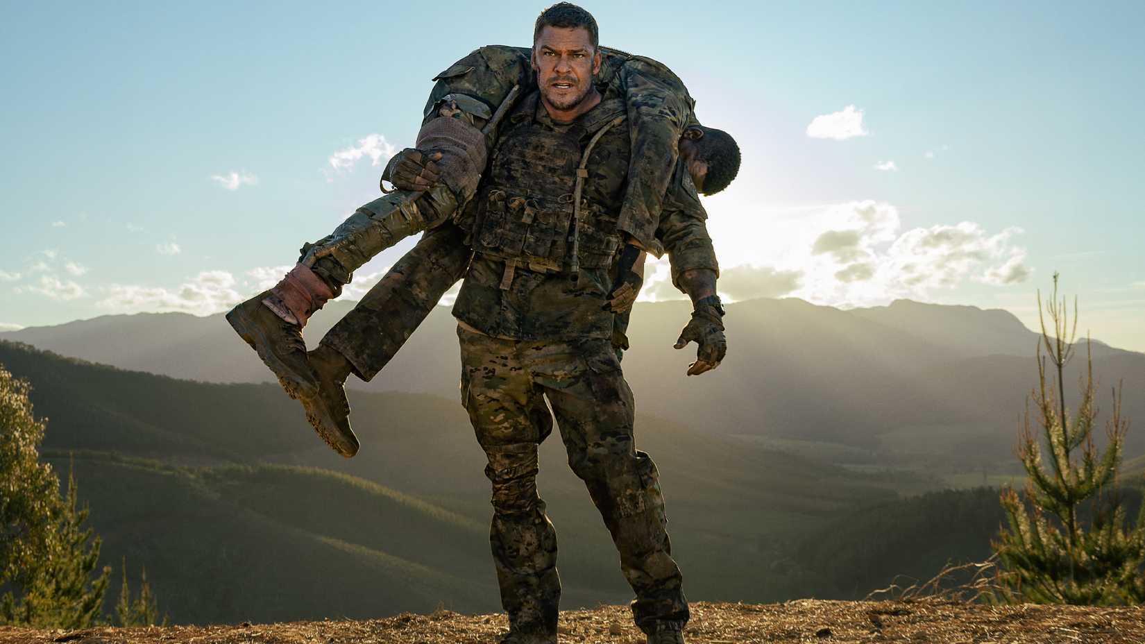 81 (Alan Ritchson) holding another soldier on his back in War Machine