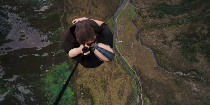 Bane and his captive on a rope hanging from a plane in The Dark Knight Rises