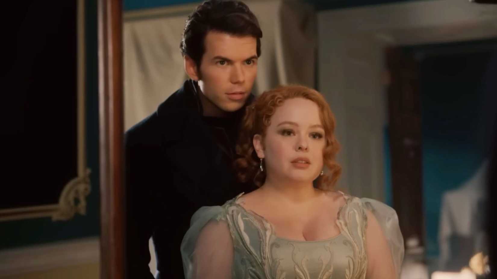 Colin and Penelope stand in front of a mirror in Bridgerton season 3.