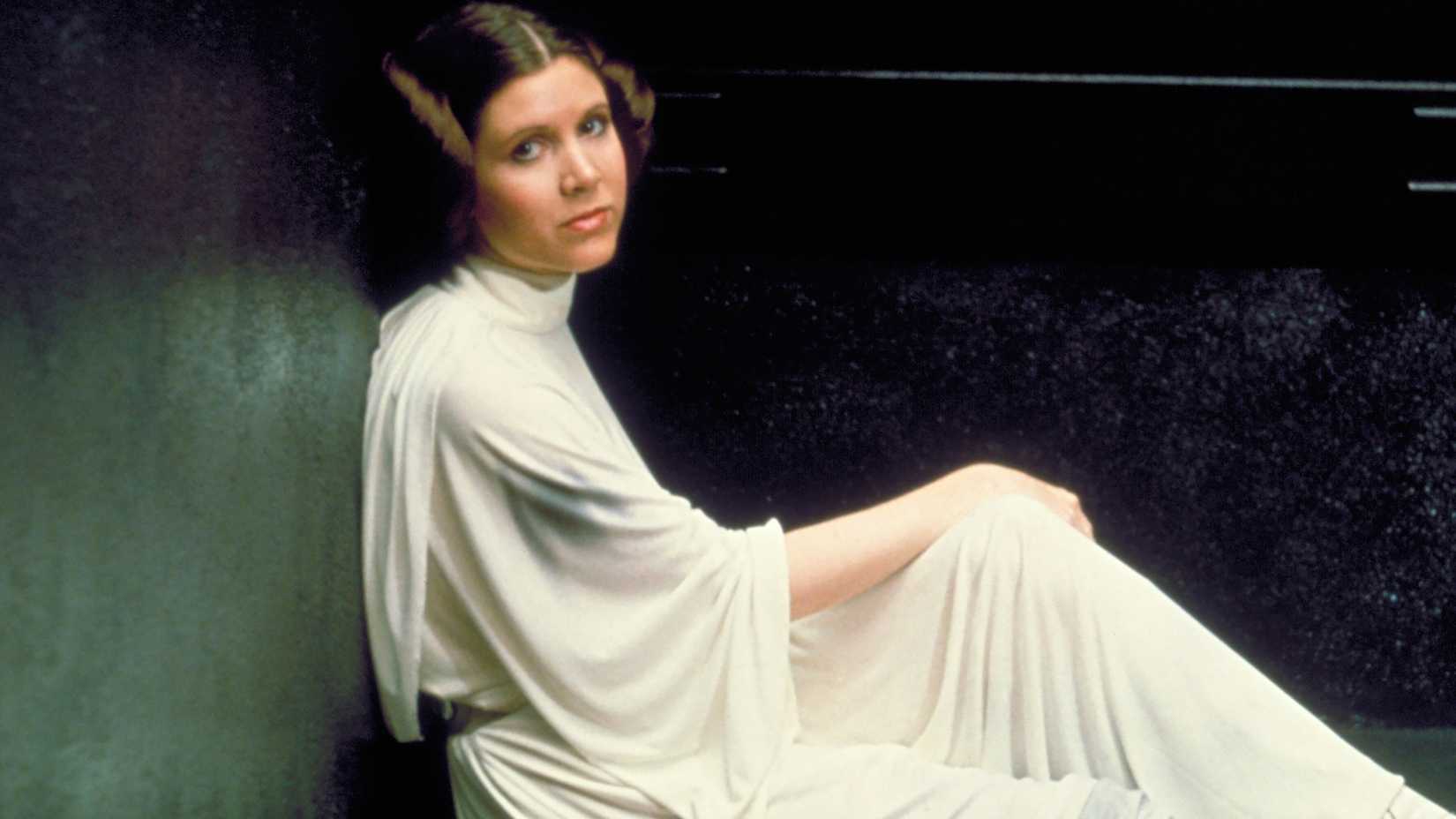 Carrie Fisher as Princess Leia sitting up in a Death Star cell in A New Hope