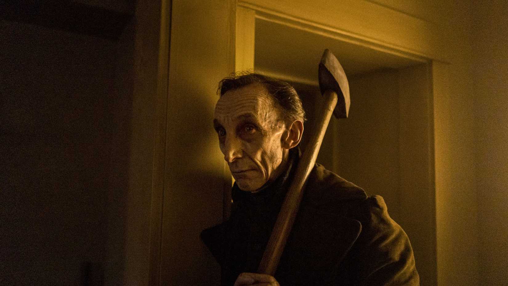 Julian Richings as Phillip Boone carrying a sledgehammer in Chapelwaite.