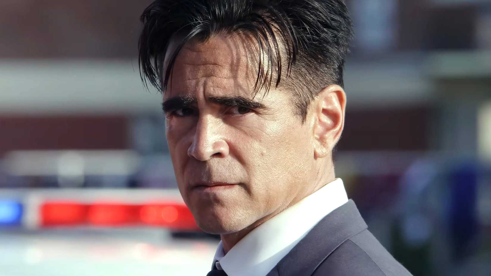 Colin Farrell's Sugar looking angrily toward the camera with a police car behind him in Sugar season 2