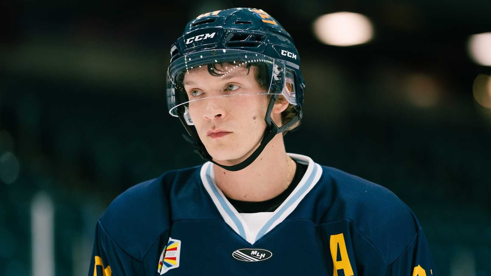 Connor Storrie in a hockey rink as Ilya Rozanov In Heated Rivalry.