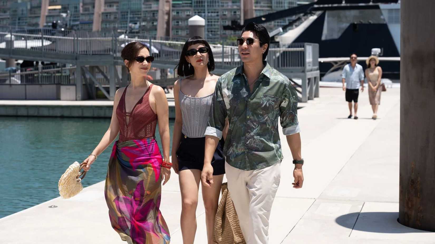 The Season still featuring three cast members walking by the harbourfront.