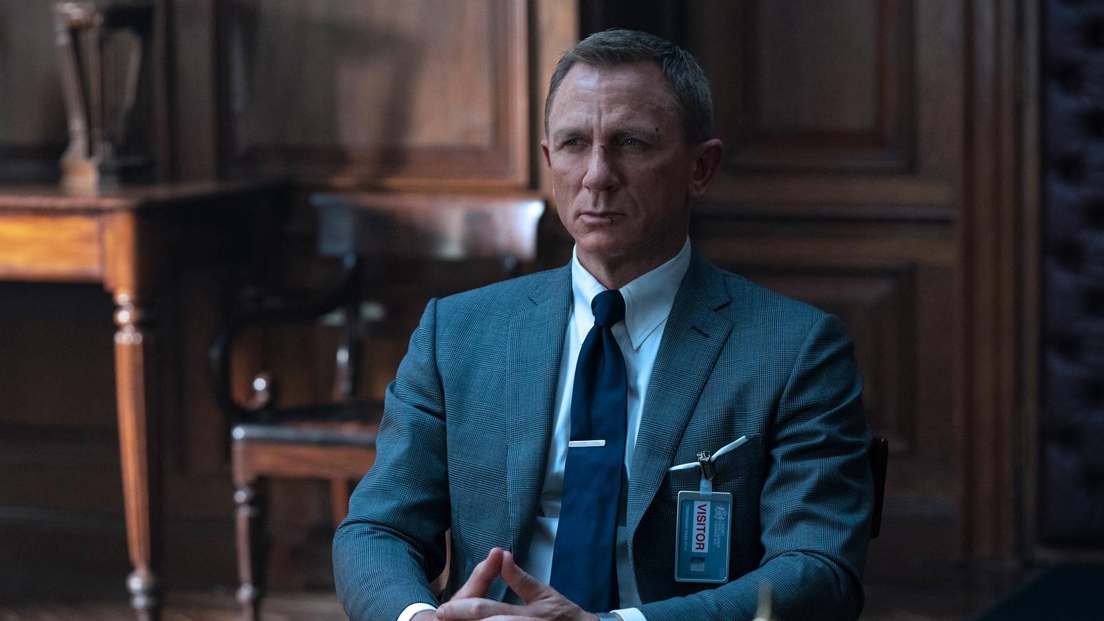 Daniel Craig as James Bond with fingers steepled in No Time to Die
