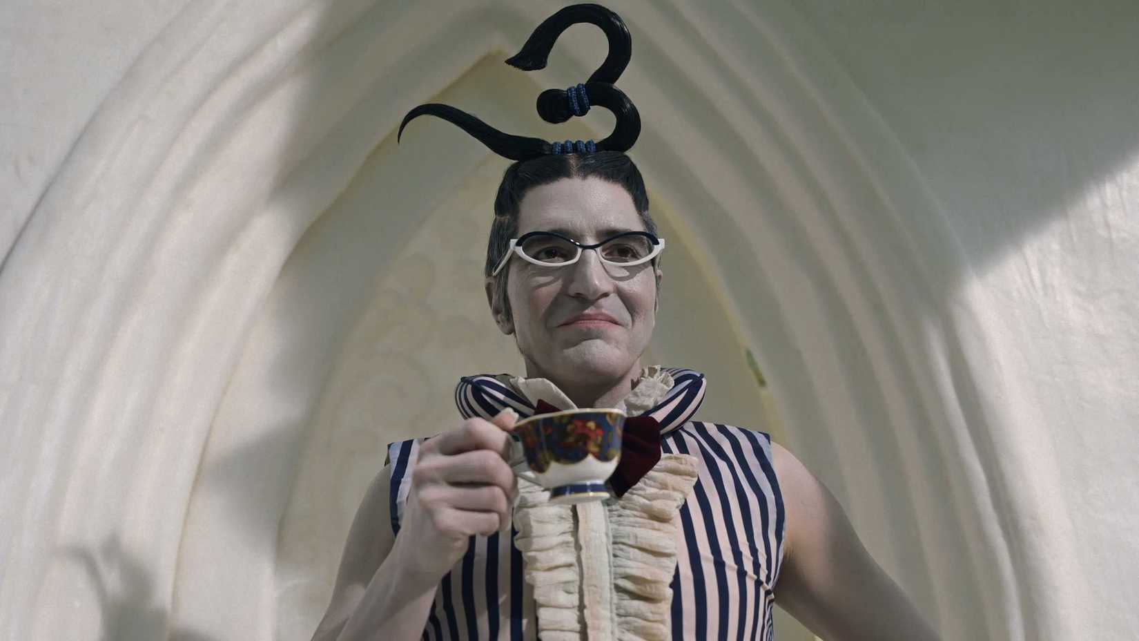 David Dastmalchian's Mr. 3 smirking and holding a cup of tea