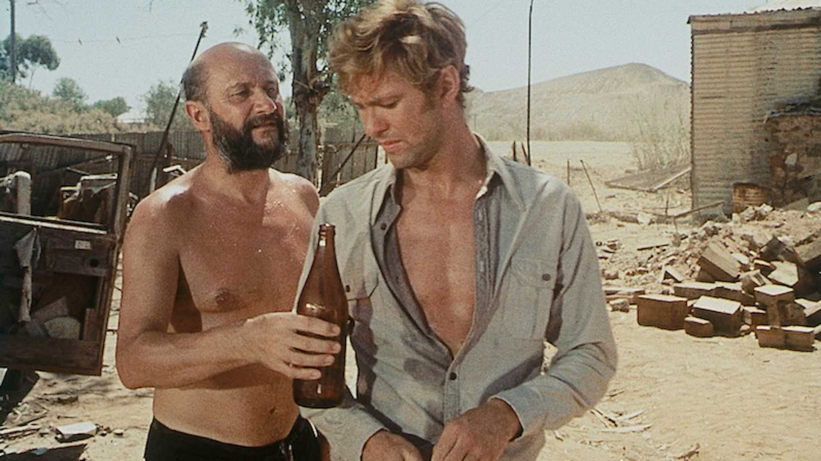 Donald Pleasence hands a man a bottle in Wake In Fright