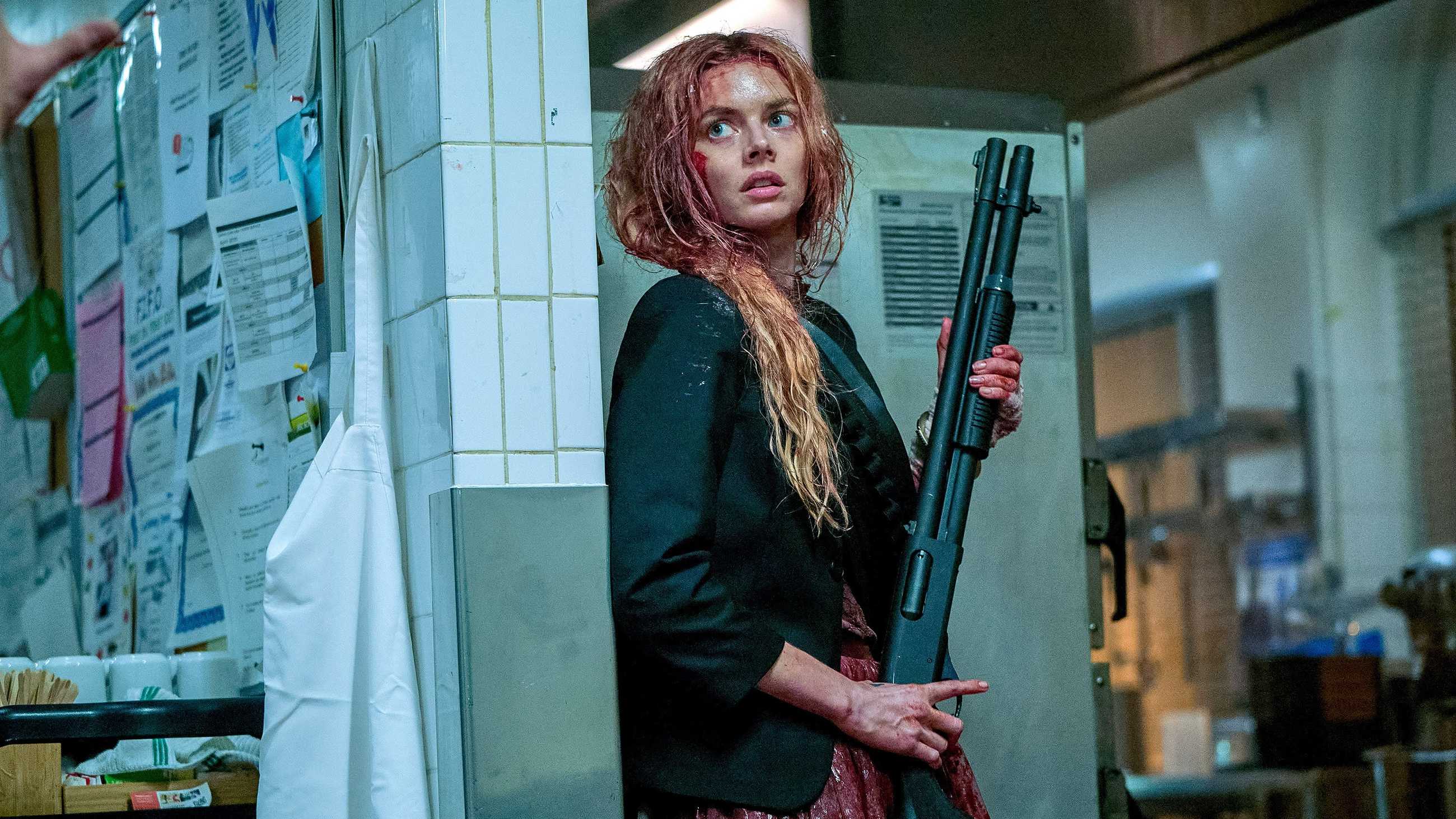 Grace bloodied and brandishing a large gun in Ready or Not 2 Here I Come