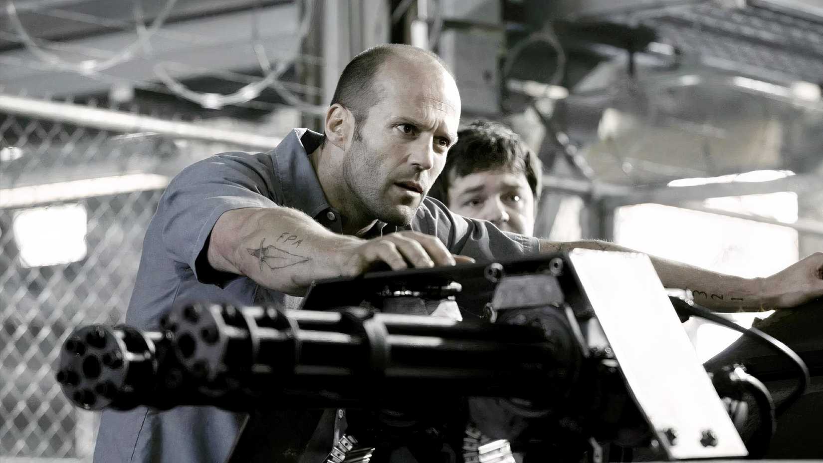 Jason Statham leans on a minigun in Death Race 2008