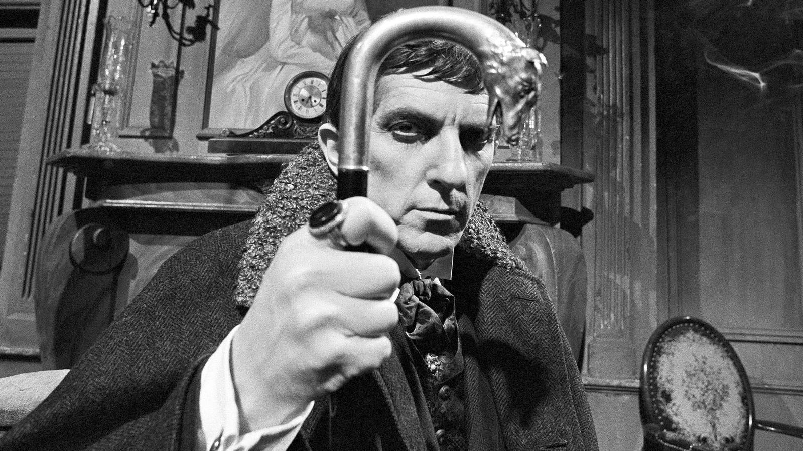 Jonathan Frid's Barnabas looking into the camera and holding his cane up in Dark Shadows