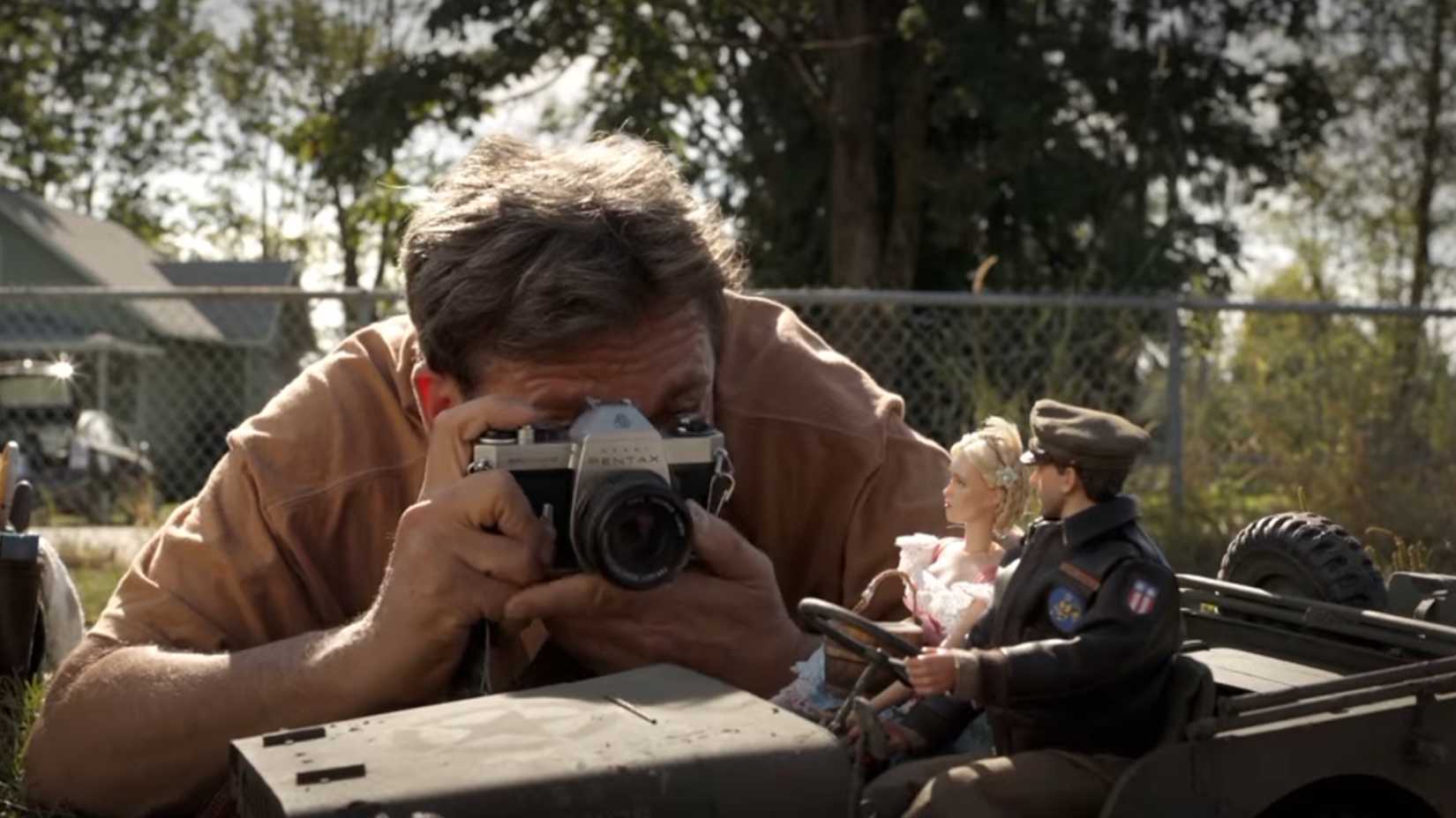 Mark Hogancamp (Steve Carell) taking pictures of a model car and passengers in Welcome To Marwen