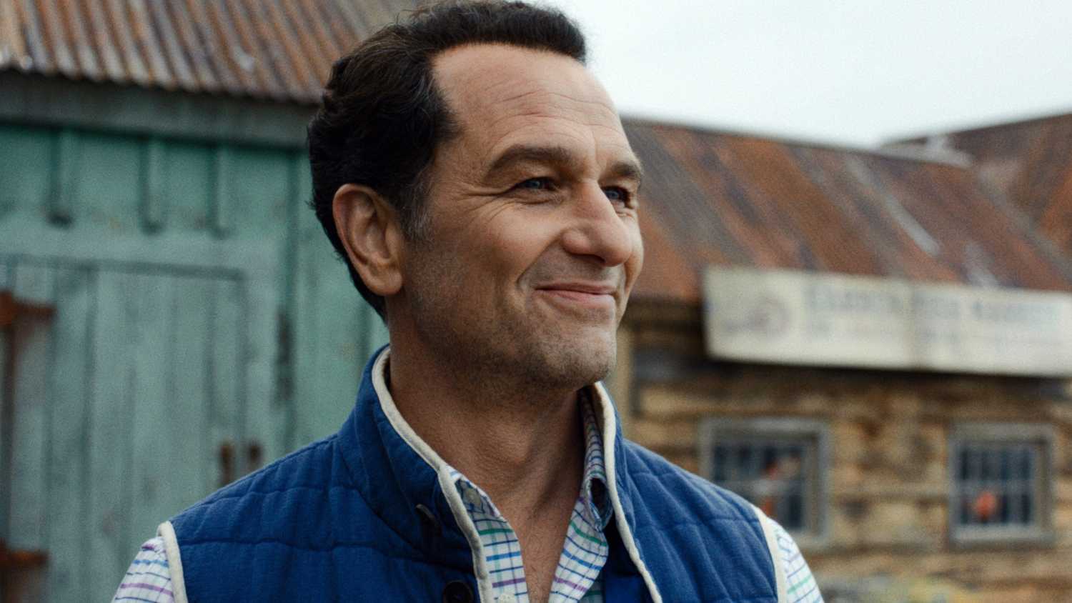 Matthew Rhys como Tom Loftis sorrindo em Widow's Bay temporada 1