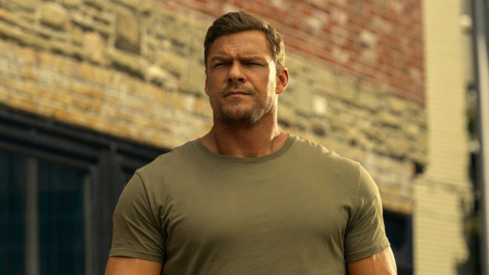 Alan Ritchson as Jack Reacher staring at someone in Reacher Season 3