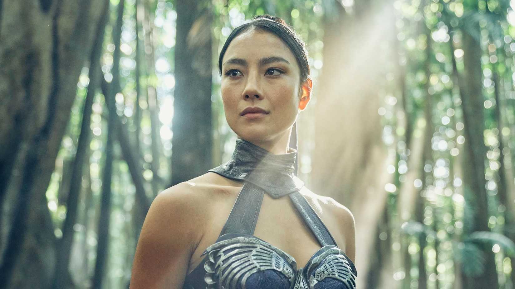 Kitana standing out in a forest as the sun is shining in Mortal Kombat II