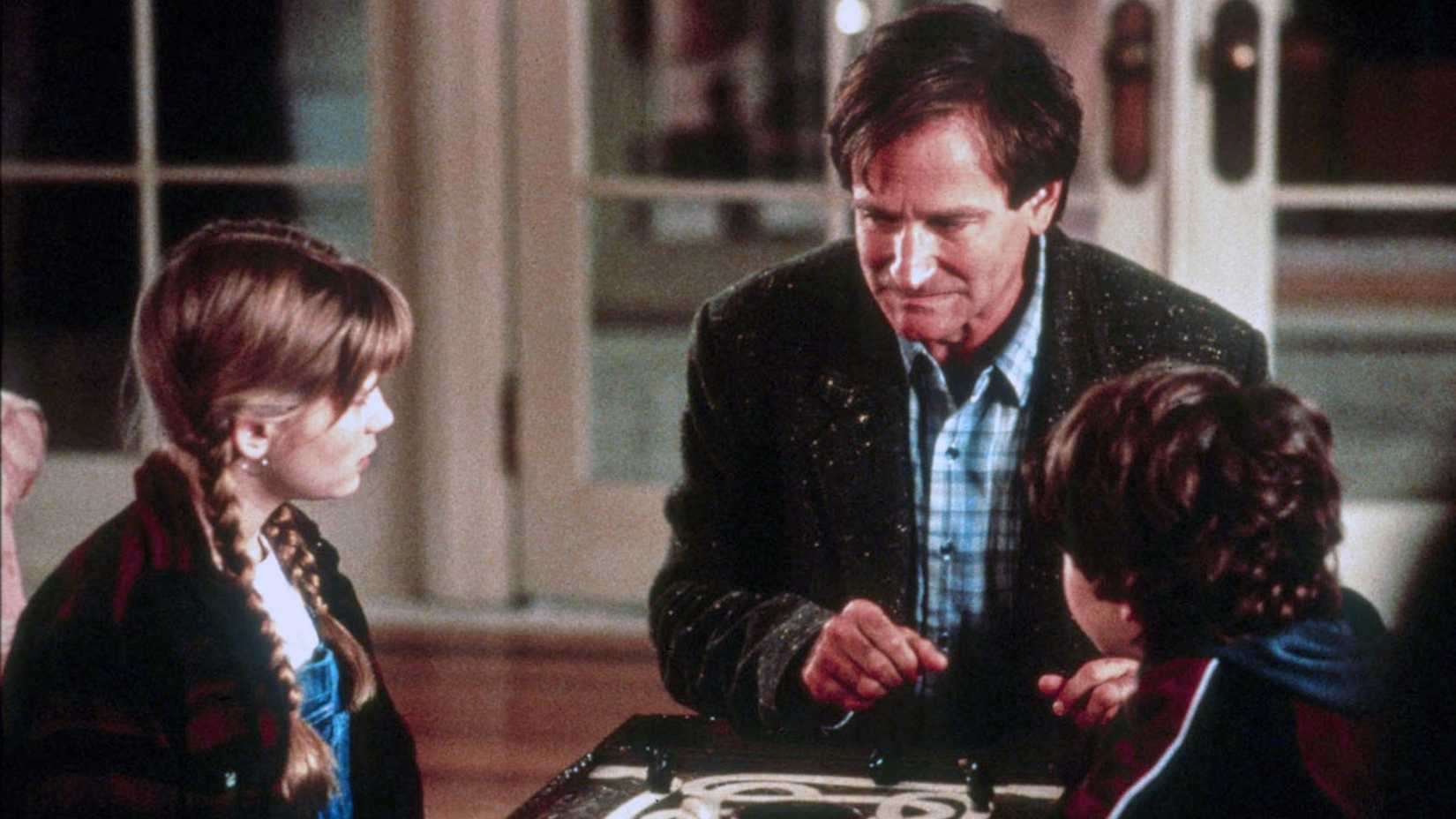 Robin Williams as Alan playing the game with Kirsten Dunst as Judy and Bradley Pierce as Peter in Jumanji