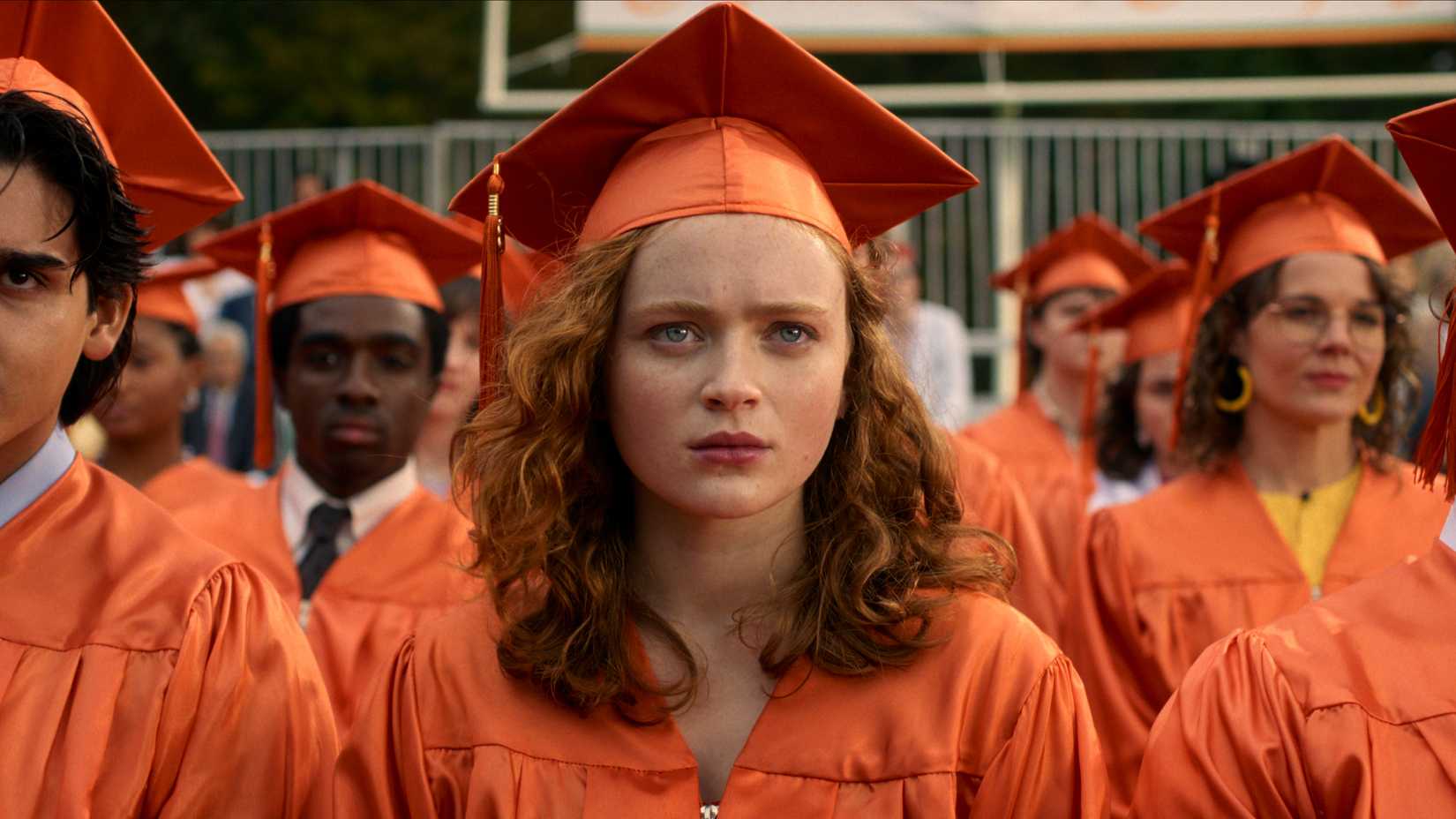 Sadie Sink's Max wears his high school graduation gown in the final episode of Stranger Things