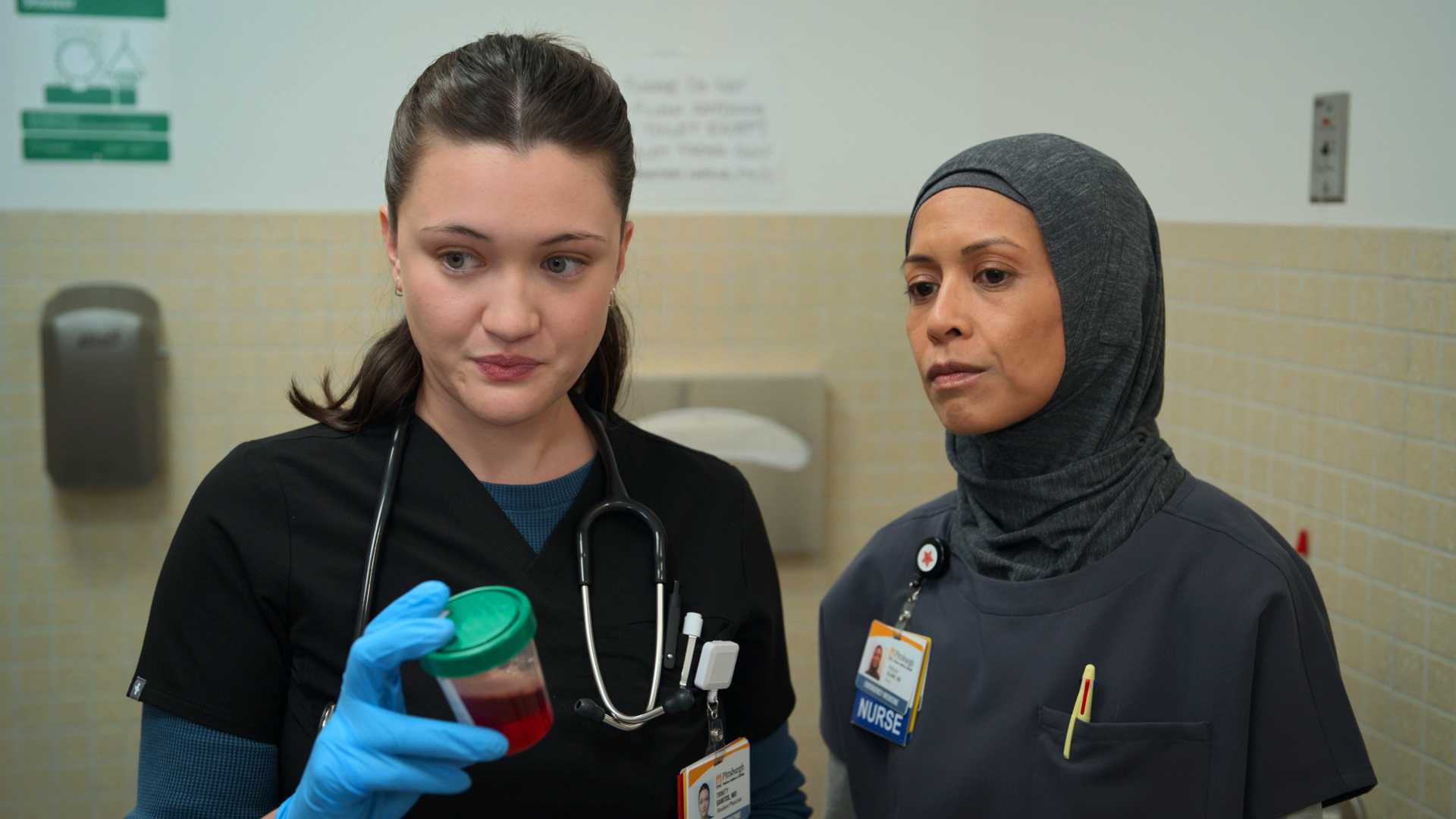 Santos and Perlah looking at a patient in The Pitt season 2, episode 1