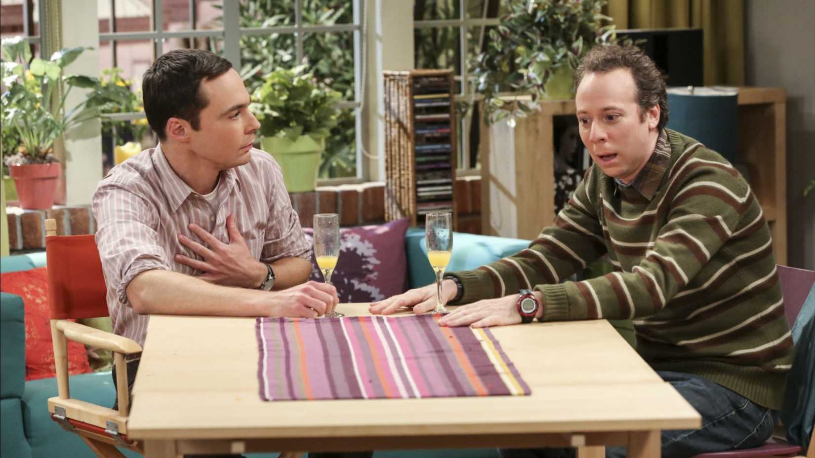 Sheldon (Jim Parsons) and Stuart (Kevin Sussman) both looking shocked while drinking mimosas in The Big Bang Theory.