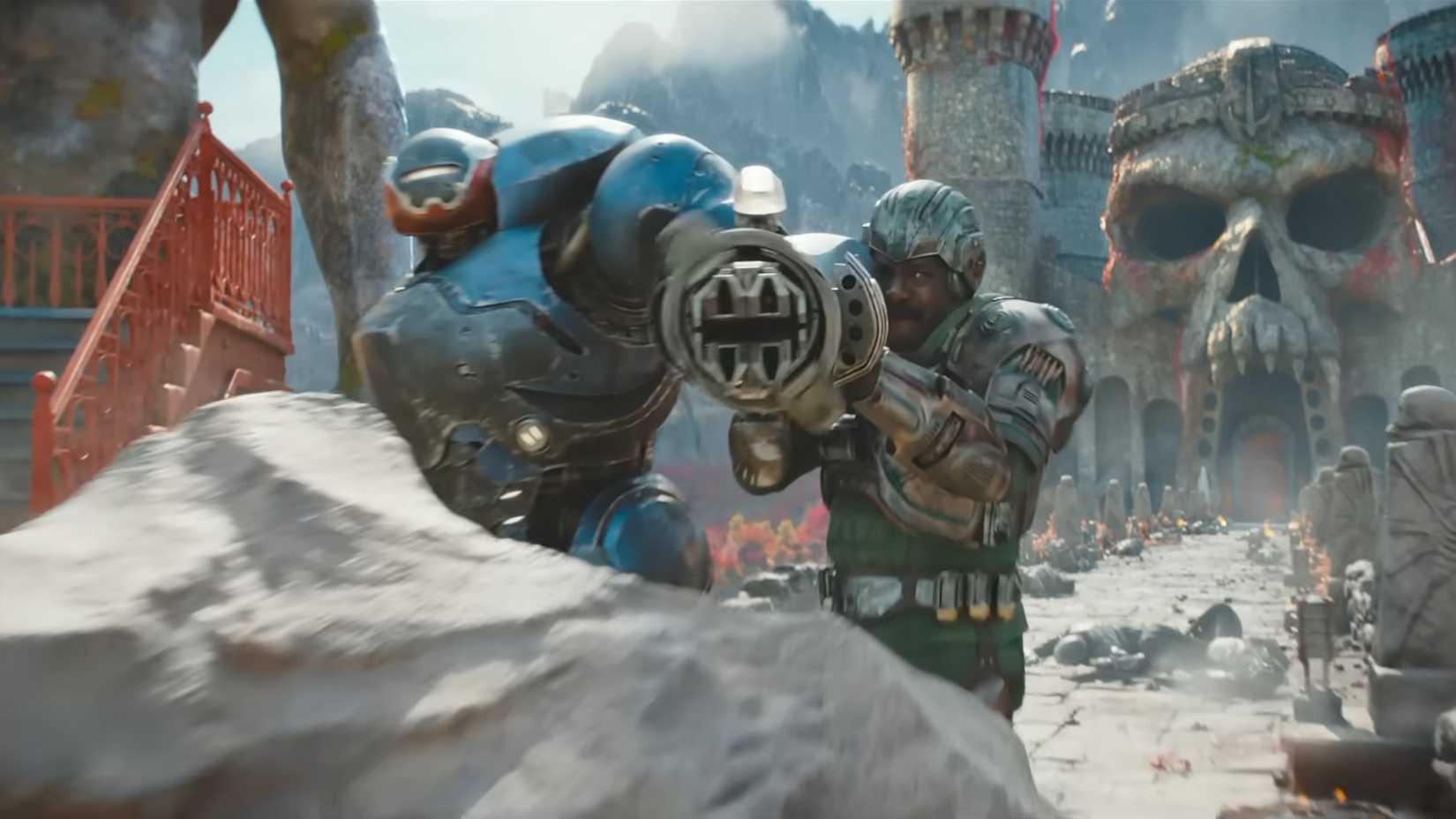 The man at arms and Roboto shooting from behind a rock in Masters of the Universe