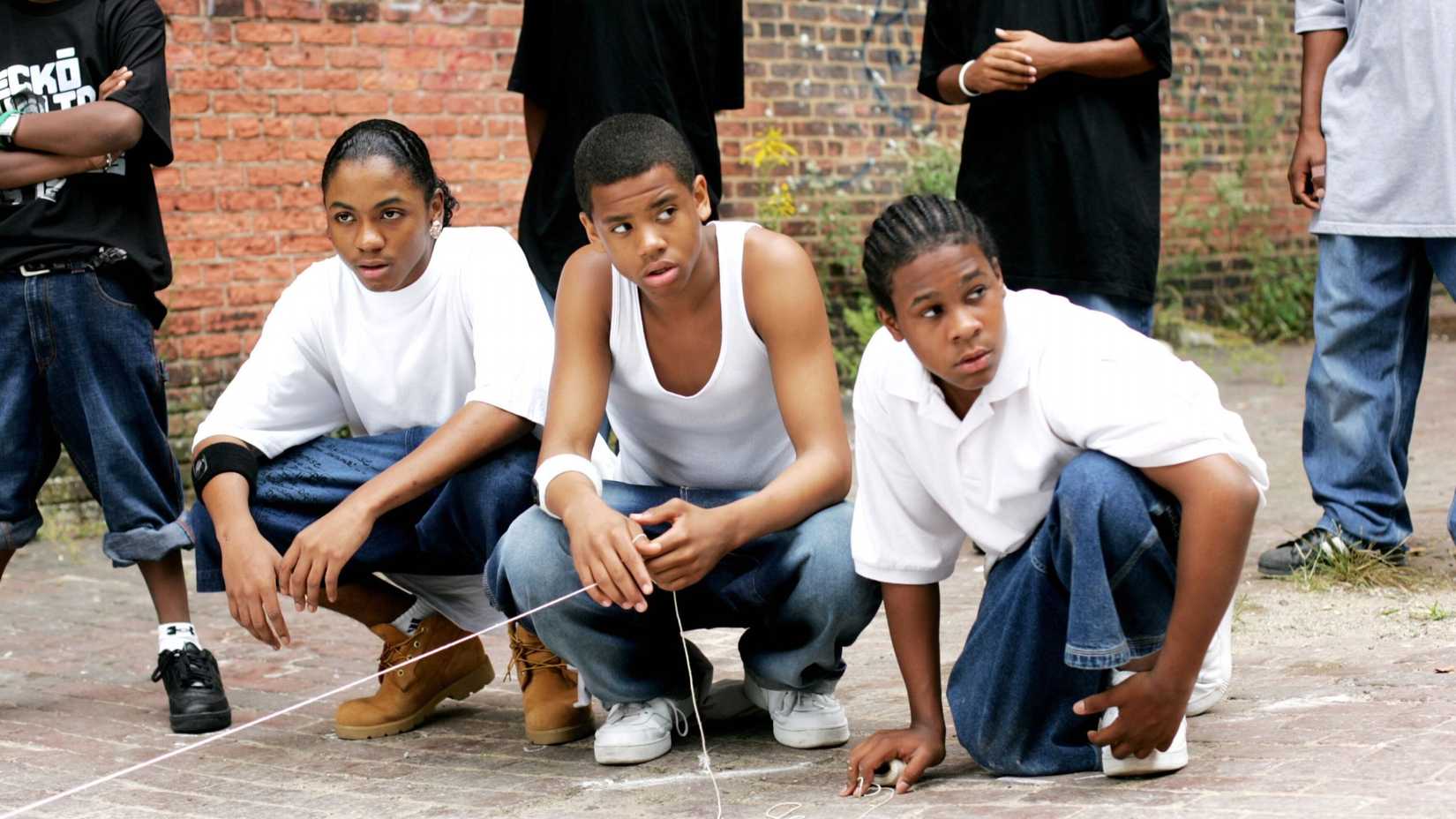 The young boys of The Wire season 4 squatting down.
