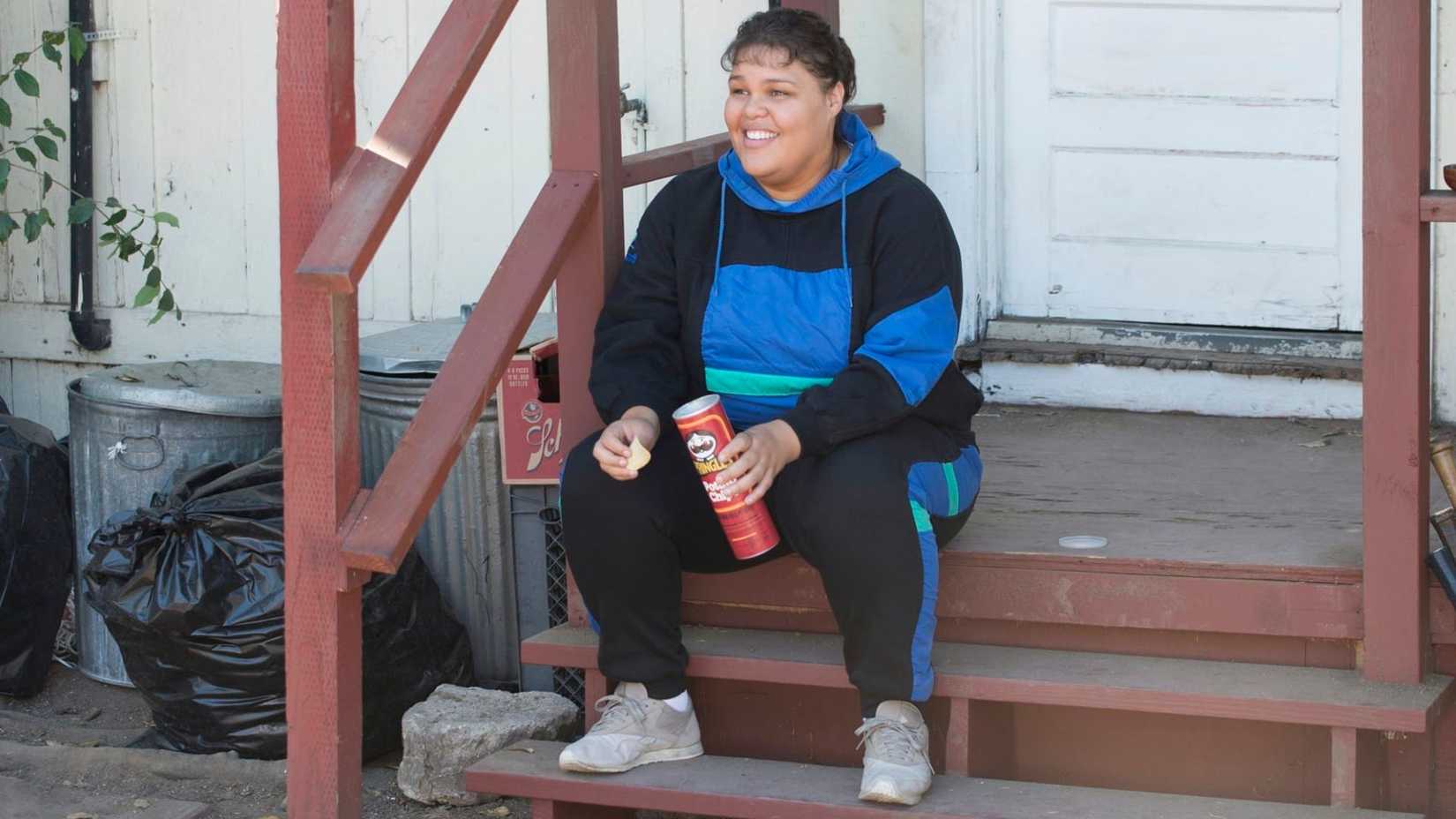 Machu Picchu sitting on the porch in a tracksuit eating Pringles