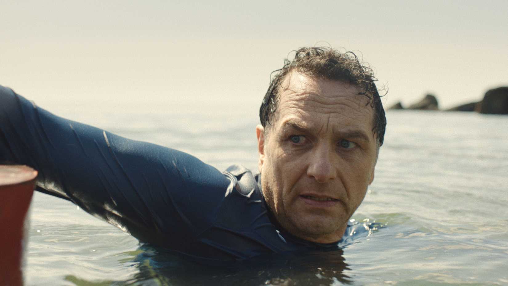 Matthew Rhys’ Mayor Tom Loftis swimming in the sea in Apple TV’s Widow’s Bay