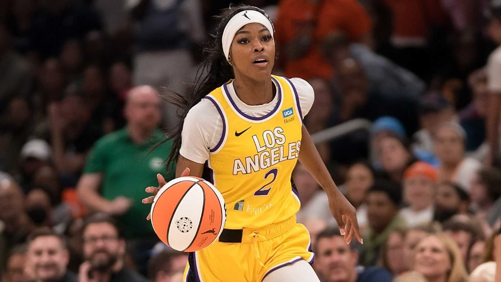 תמונה של שומר ה-WNBA של לוס אנג'לס ספארקס, תה קופר, במשחק, מכדרר את הכדור במעלה המגרש.