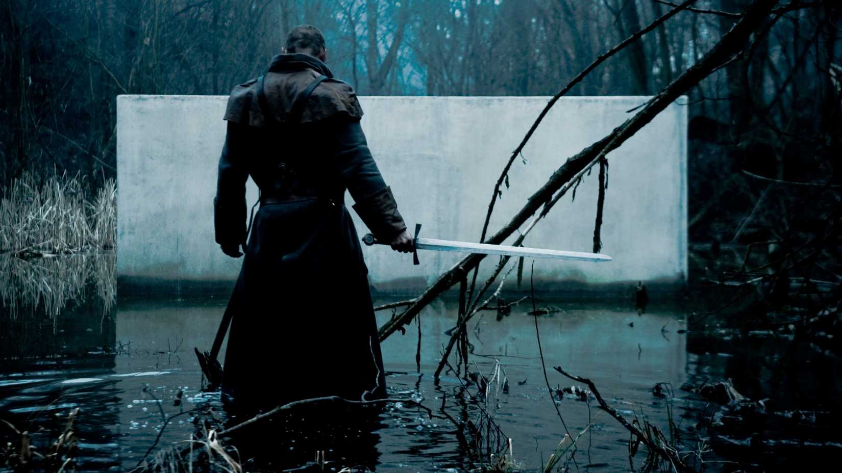 A man with a sword in a lake in Evil Rise AKA Sauna