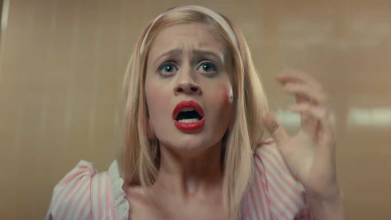 A woman looking terrified as a red mark on her face is ready to burst in Scary Stories to Tell in the dark