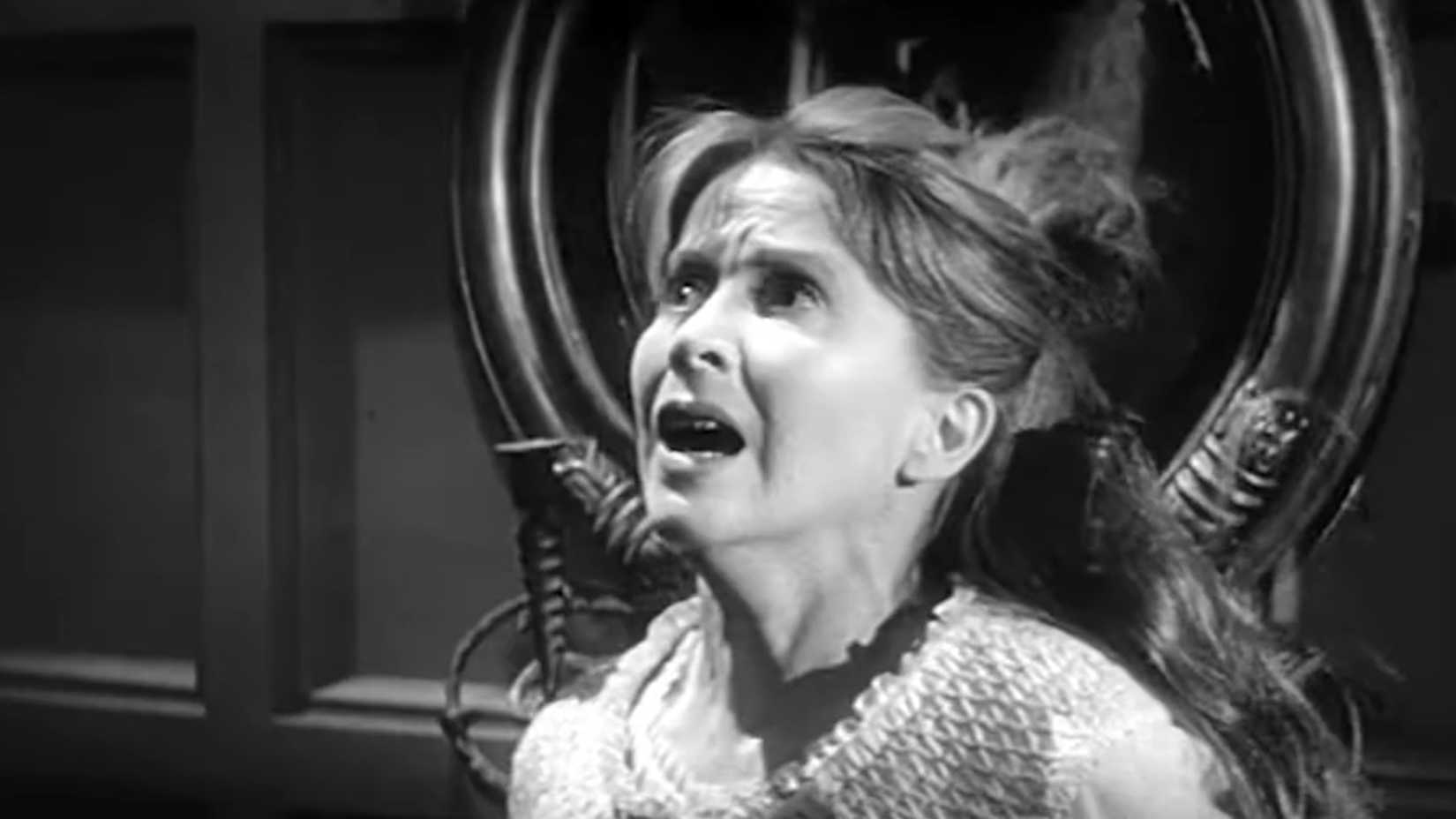 אישה נראית מבועתת עם מראה מאחוריה ב-The Haunting 1963