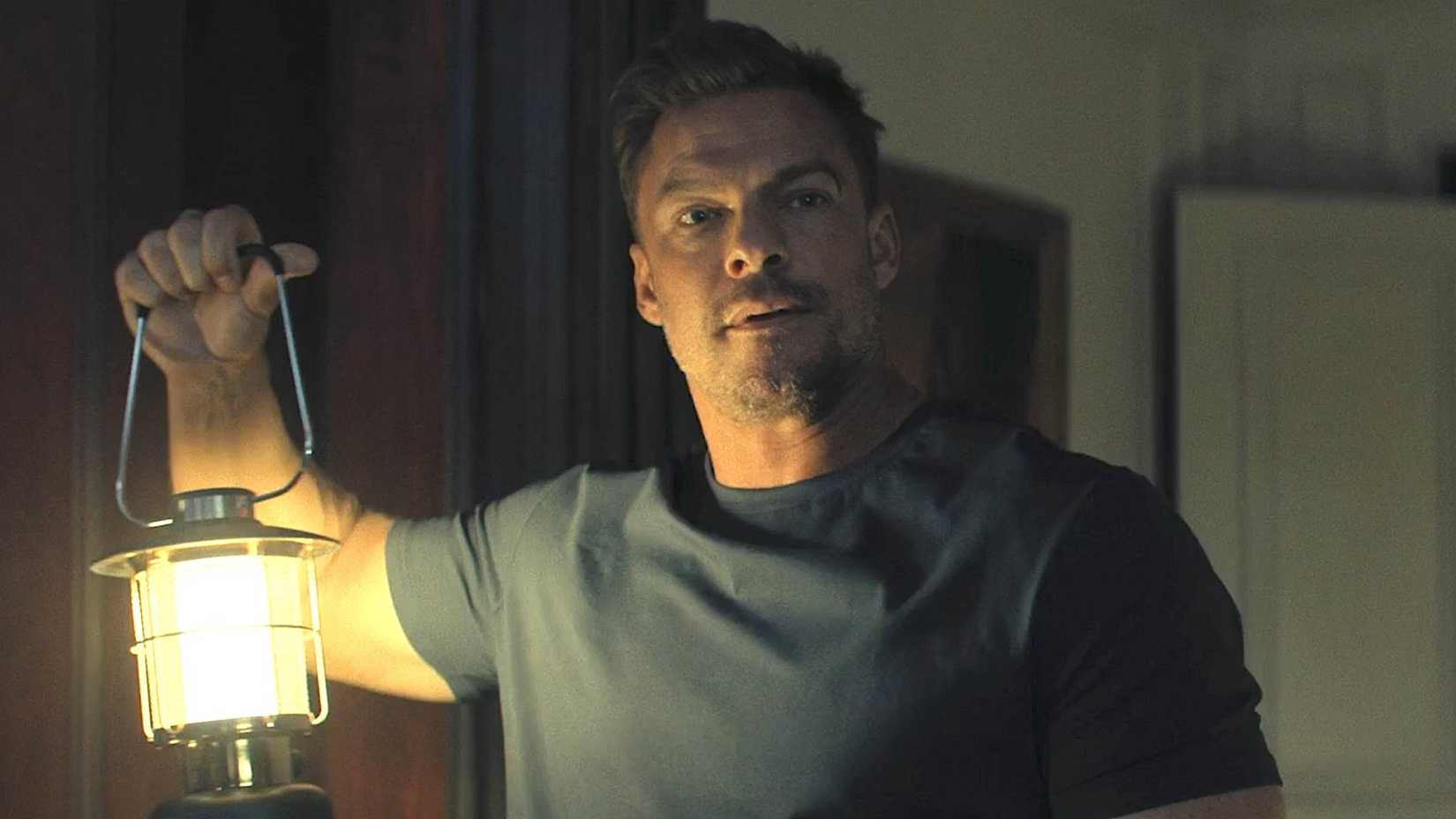 Alan Ritchson's Reacher holds up a lamp in Reacher season 3