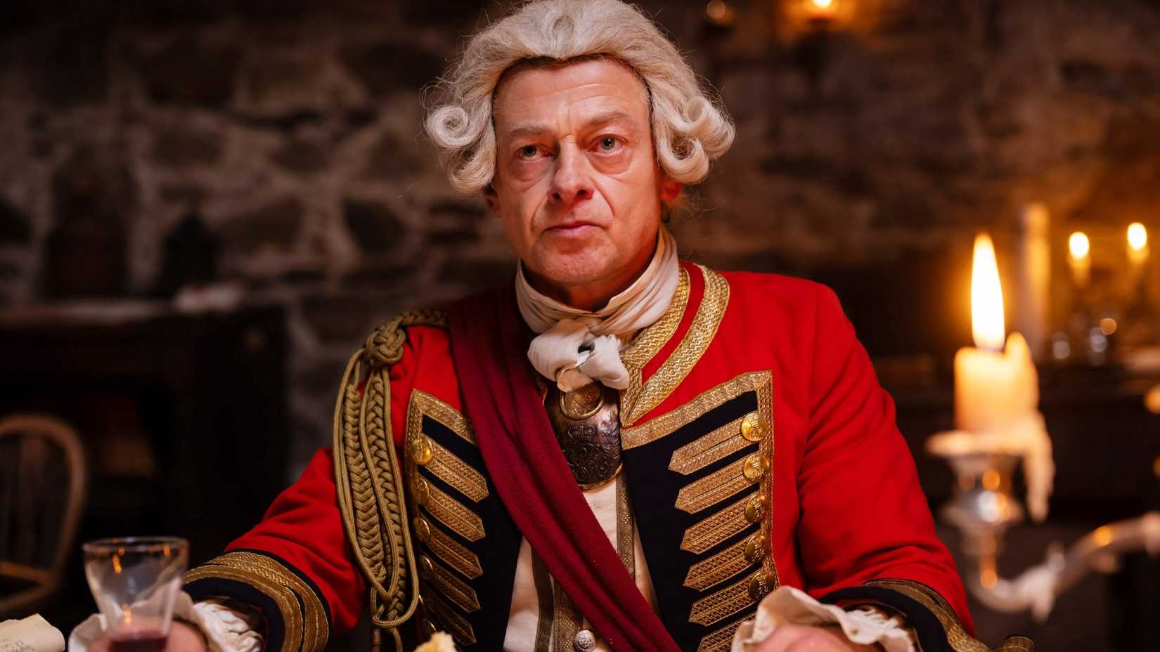 Andy Serkis as Edward Braddock sitting in Young Washington