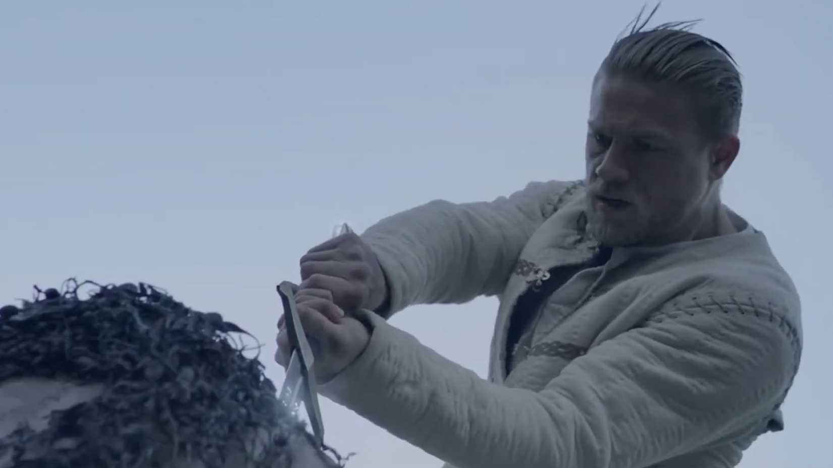 Arthur (Charie Hunnam) pulling Excalibur out of the stone in King Arthur Legend of the Sword