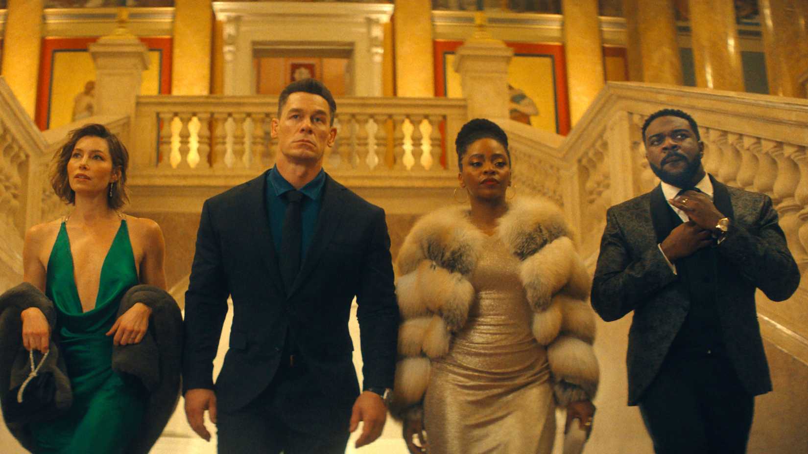 Arturo Castro, Jessica Biel, John Cena, Teyonah Parris and Sam Richardson walking into a building dressed fancily in Matchbox(1)