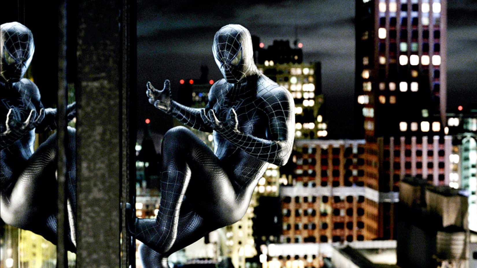 Tobey Maguire's Spider-Man in his black suit standing on the side of a building at night