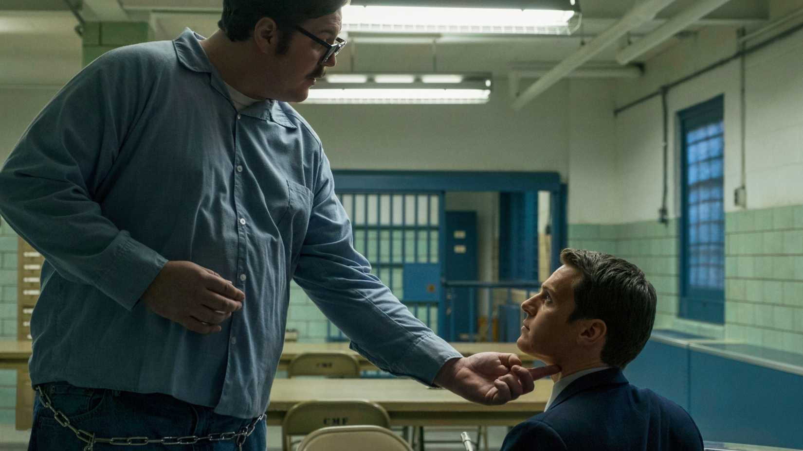 Cameron Britton touching Jonathan Groff's chin in Mindhunter season 1