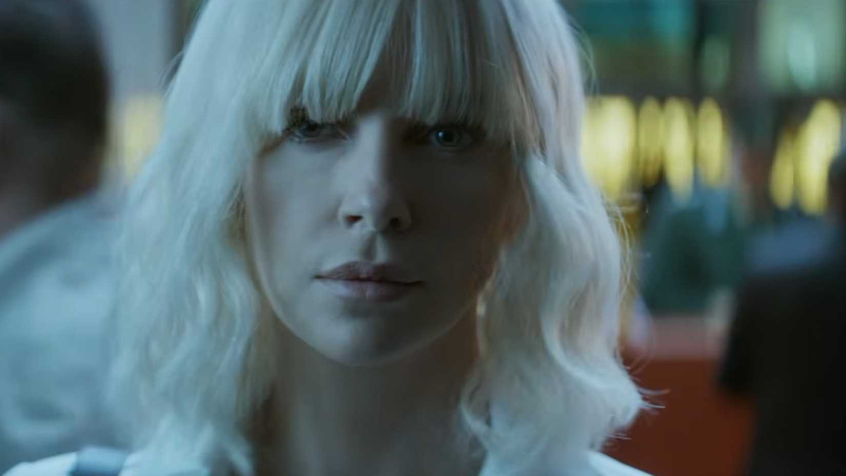 Charlize Theron removes her sunglasses in Atomic Blonde