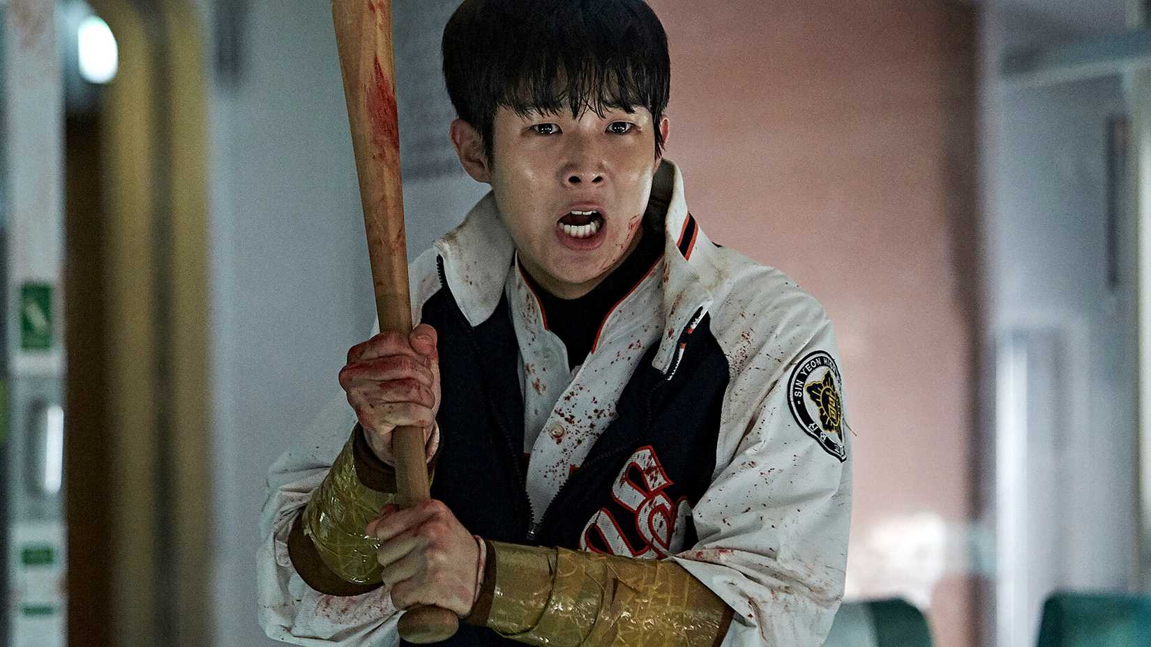 Choi Woo-shik looking scared while holding a bat in Train to Busan