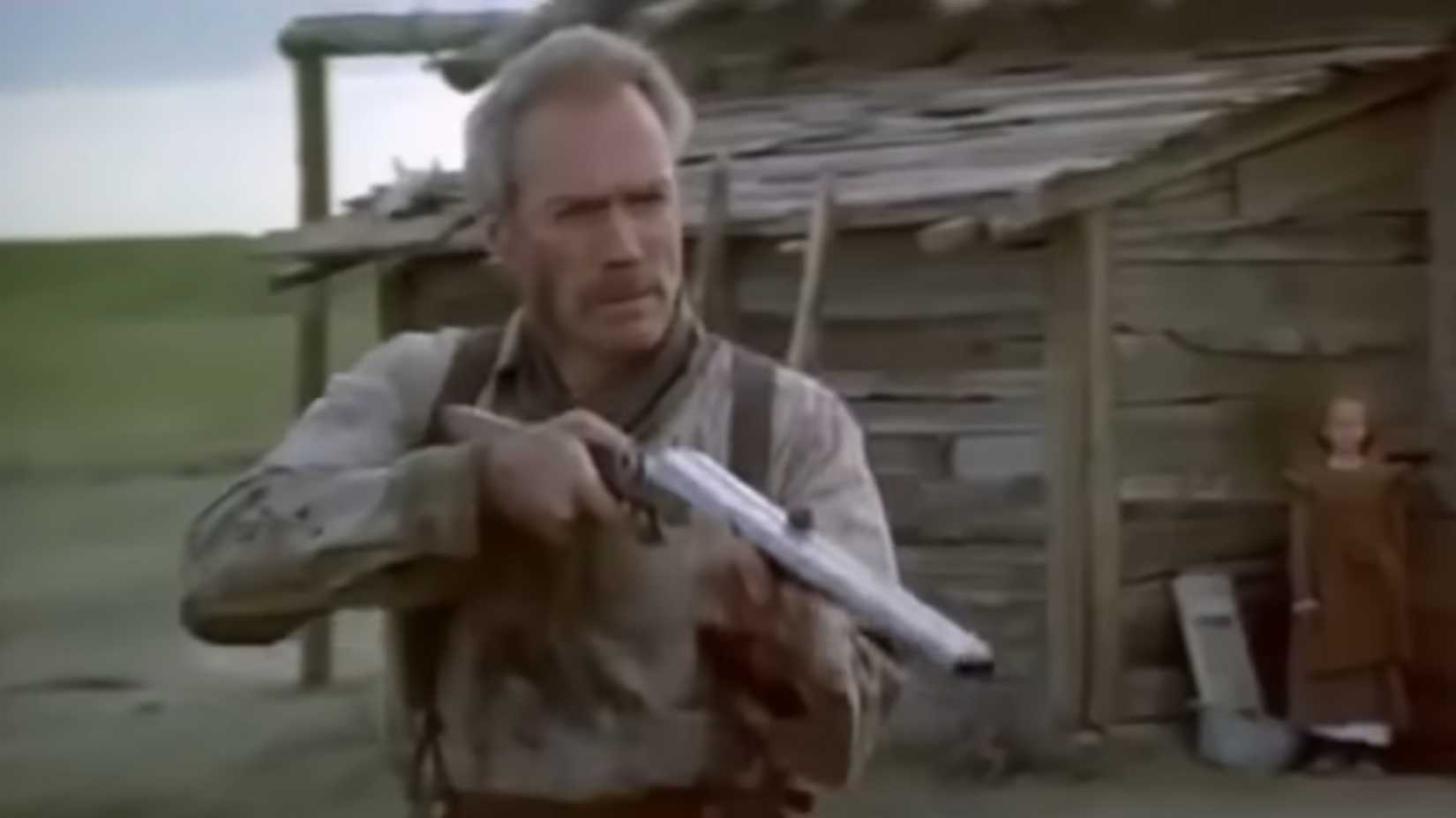 Clint Eastwood raises a shotgun in Unforgiven