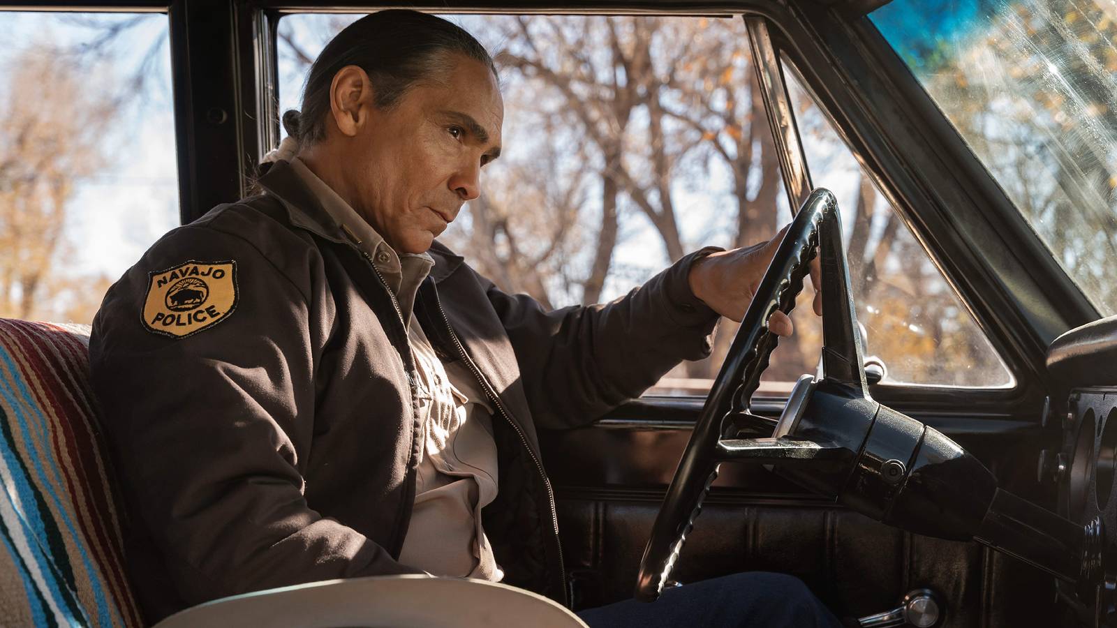 Still of Zahn McClarnon as Lt. Joe Leaphorn wearing his Navajo Police uniform in Dark Winds season 2.