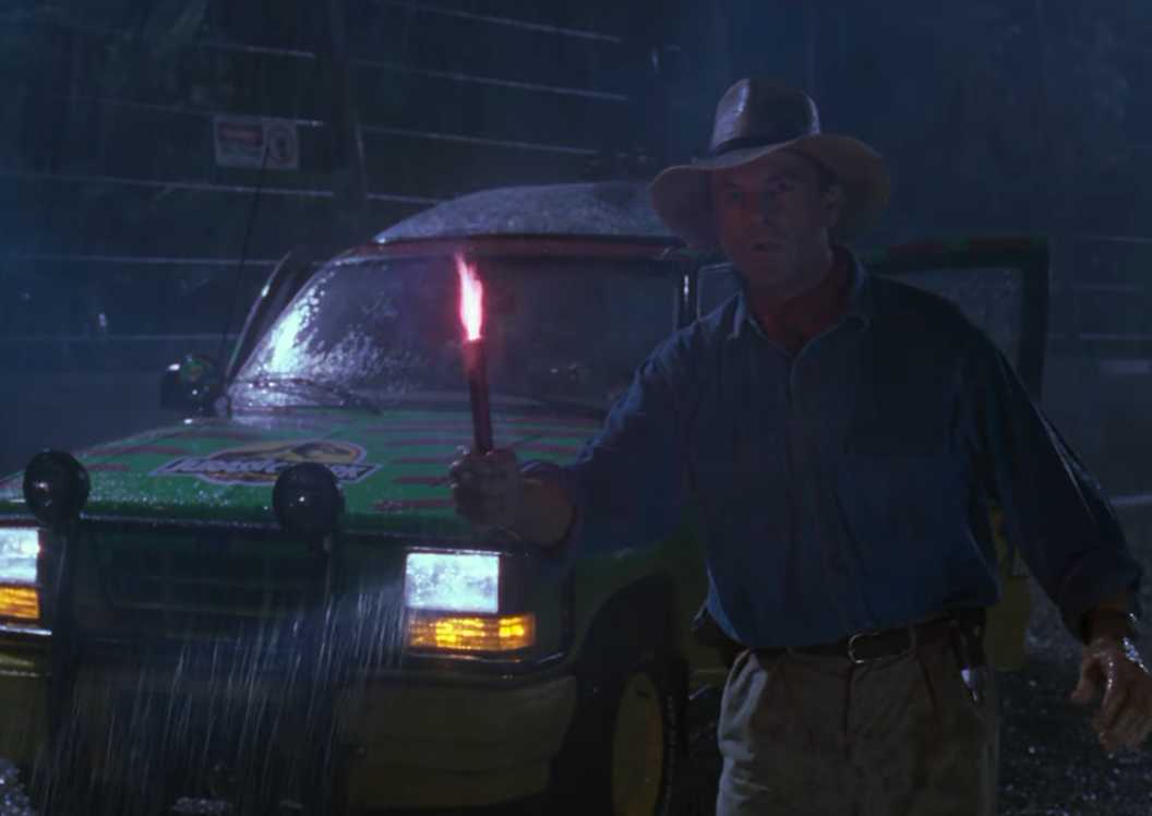 Dr Grant (Sam Neill) holding a flare as the t rex escapes in Jurassic Park
