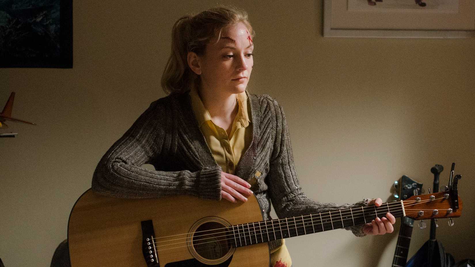 Emily Kinney as Beth holding a guitar in The Walking Dead