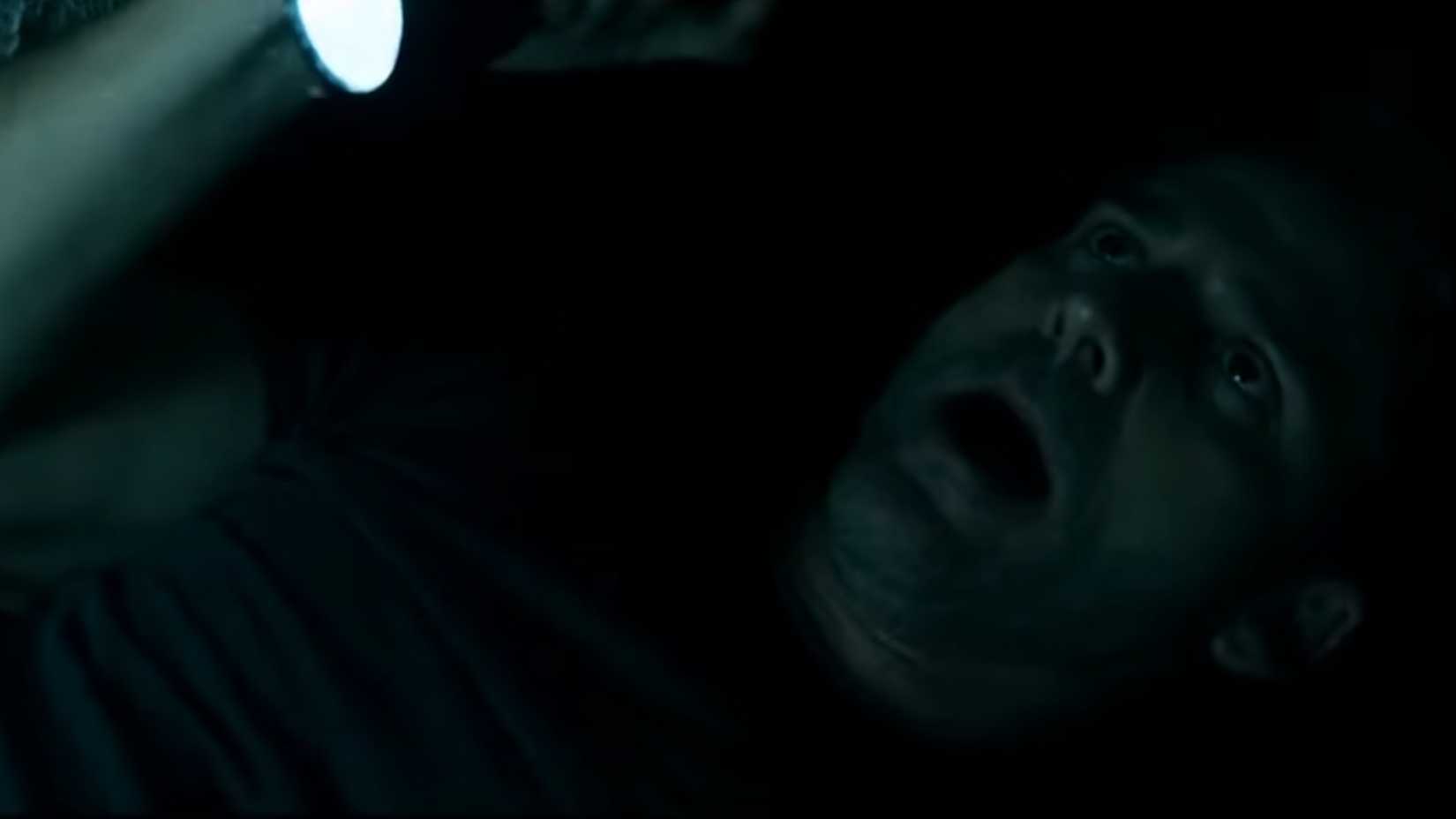 Eric Bana as Sarchie on his back holding a flashlight in Deliver Us From Evil