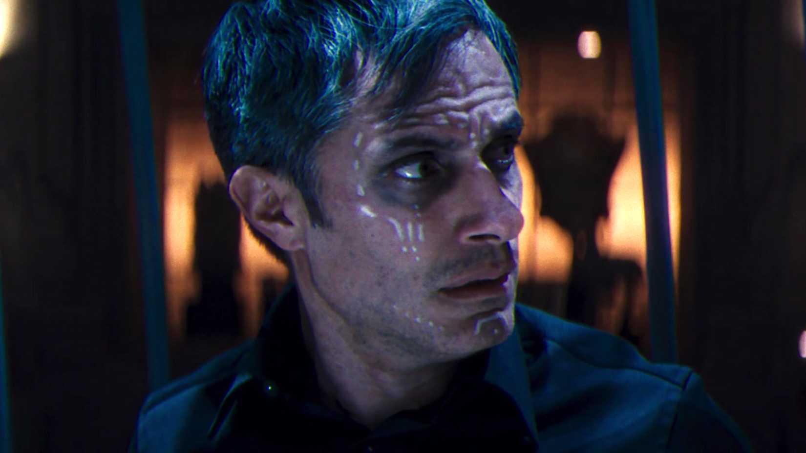 Gael Garcia Bernal's Jack looking worriedly to the side while in a cage in Werewolf by Night