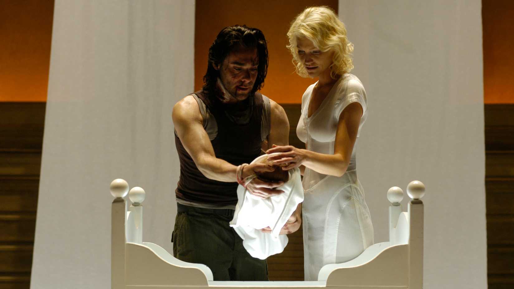 Gaius and Six holding a baby in Battlestar Galactica.
