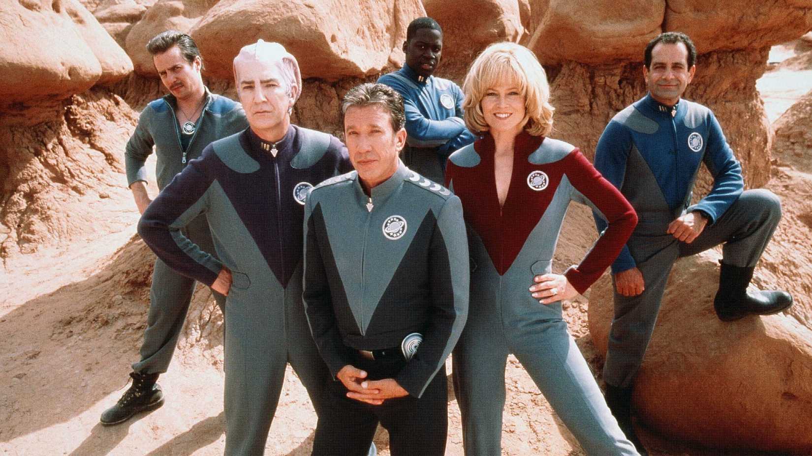 The cast of Galaxy Quest pose near some boulders